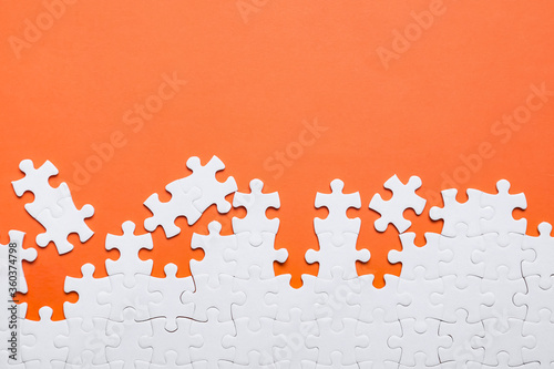 Blank white puzzle pieces on orange background, flat lay. Space for text