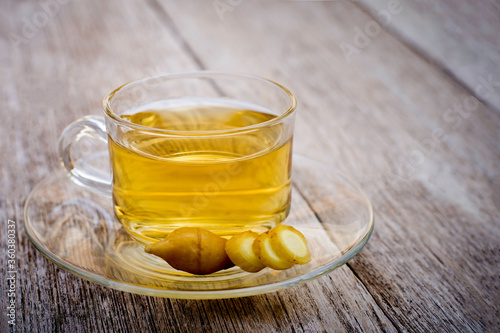 Cup of fingerroot tea with finger root ( Chinese Ginger, Galingale, Kaempfer, Boesenbergia rotunda, Krachai ) isolated on wood table background.