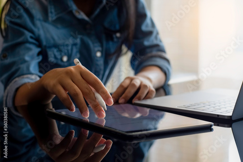 Close up of female hands working on digital tablet computer.
