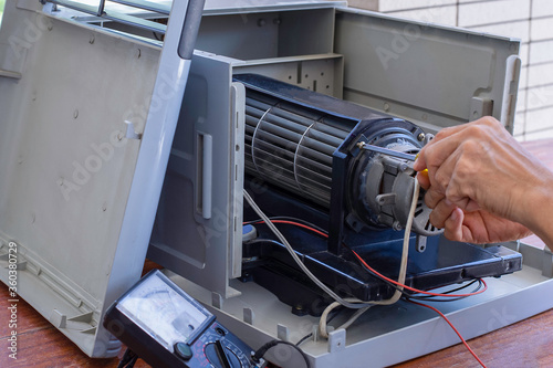 Hand repair the electronic evaporative fan. Maintenance concept. photo