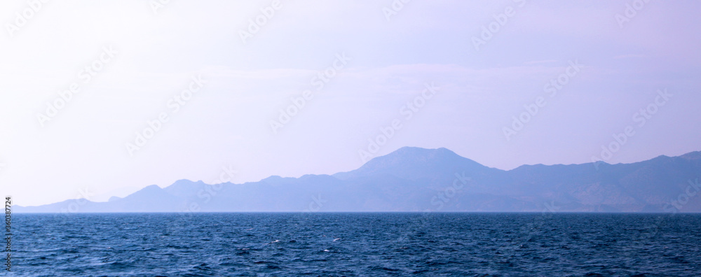 Silhouette of a rocky island in the morning haze, calm sea at dawn
Silhouette of a rocky island in the morning haze, calm sea at dawn