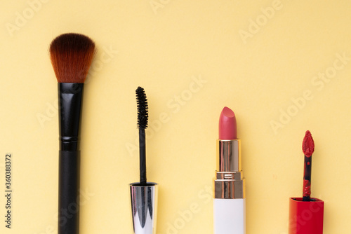 Top view. Flat lay. Cosmetic make up tools set collection over bright yellow background.