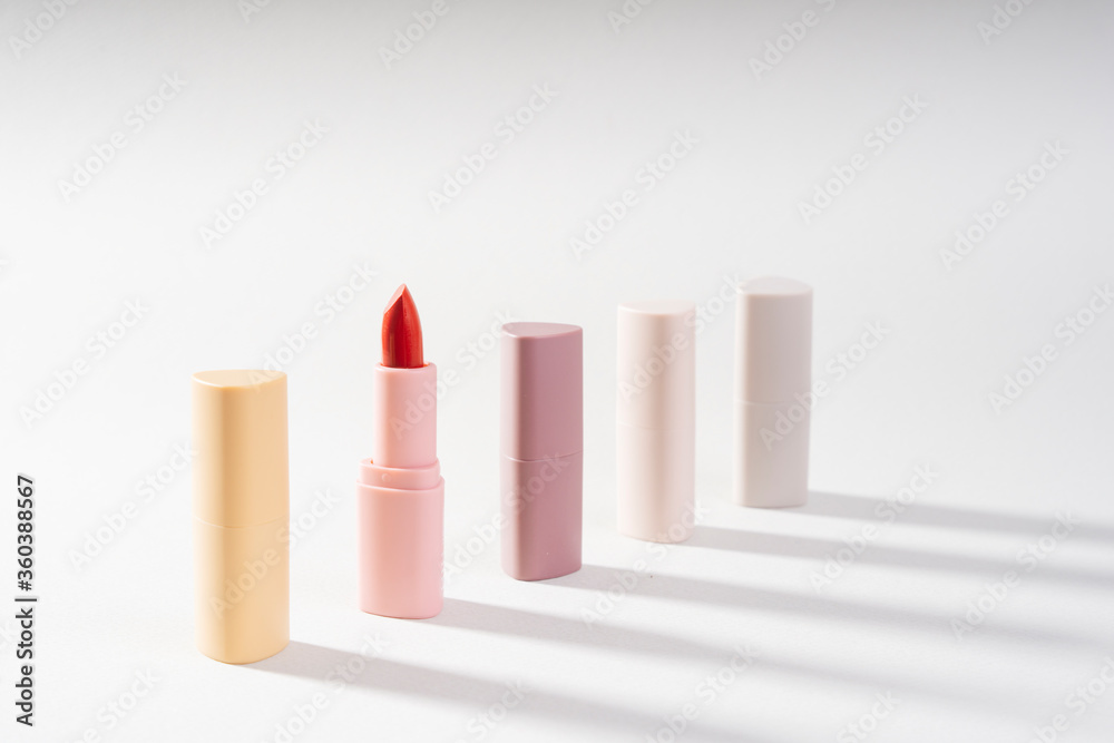 Group of brown pink lipstick over white background.