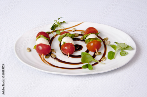 Plate of tomato and cheese salad on white backgroundPlate of tomato and cheese salad on a white background