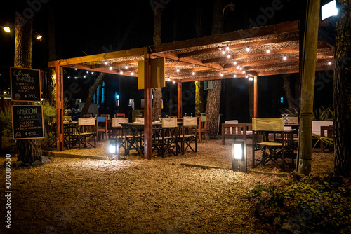 Night scene of an elegant outdoor bar illuminated by small hanging bulbs