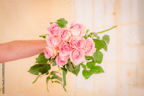 Women hand holding a bouquet of Luciano roses variety, studio shot.