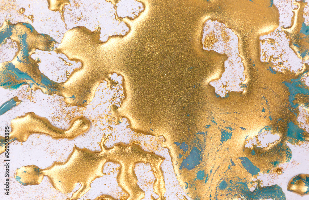 Golden ink drops on white paper background. Golden ink drops on white paper background.