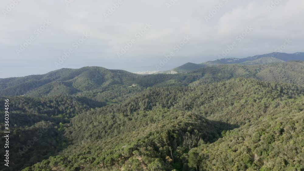Scenic flight above green lush hills and mountains in countryside toward ocean sea coastline, above aerial approach Scenic flight above green lush hills and mountains in countryside toward ocean sea coastline, above aerial approach