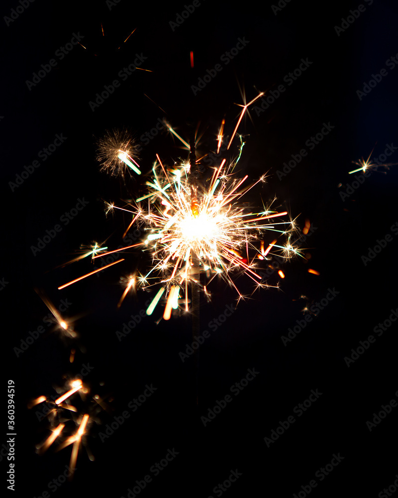 Lighting a Firework Sparkler In Celebration of the Holidays Crackling in the Dark