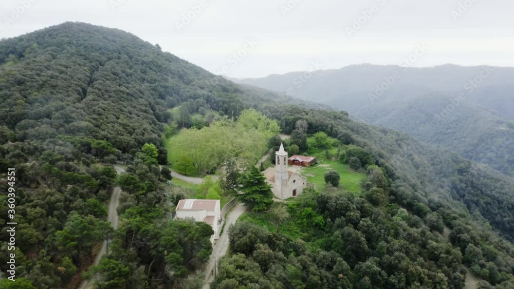 Scenic flight towards old historic church with dirt trail for Tordera trailrace in rural countryside, overhead aerial approach Scenic flight towards old historic church with dirt trail for Tordera trailrace in rural countryside, overhead aerial approach