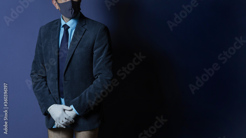 businessman in a sanitary mask and medical gloves, spreads his hands, was left without pants, no money, isolated on background. Business crisis during a pandemic.
