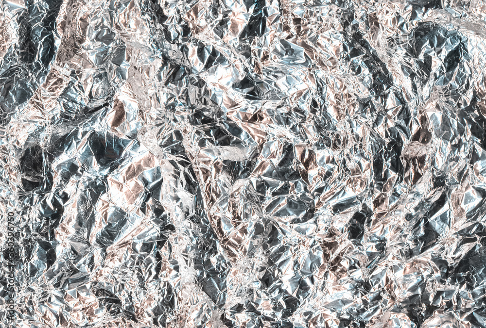 Crumpled metallic background. Crushed texture. Shiny silver gray distressed foil. Crumpled metallic background. Crushed texture. Shiny silver gray distressed foil.