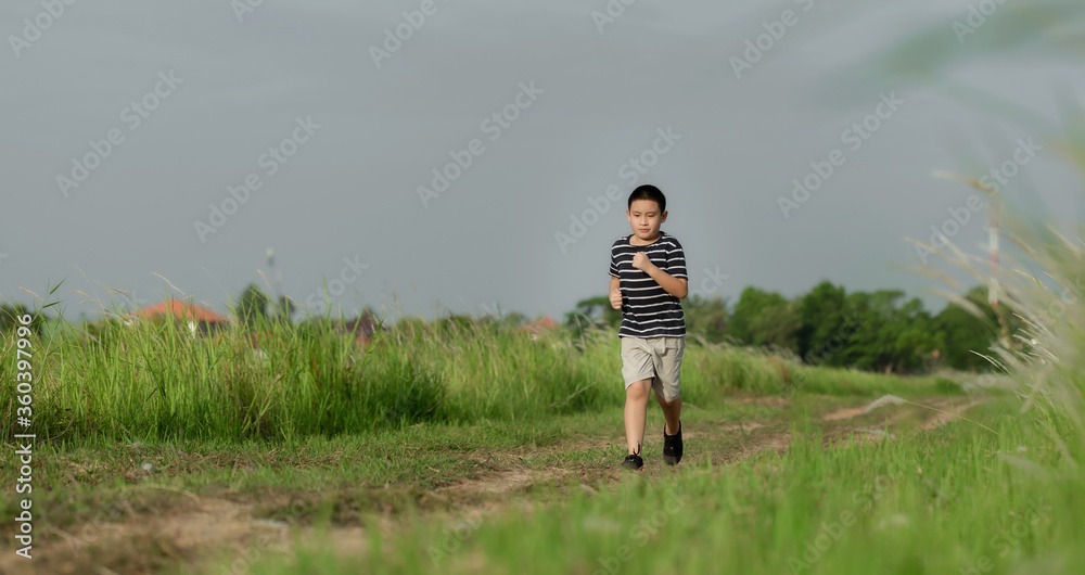 Cute boy running in nature and smiling.