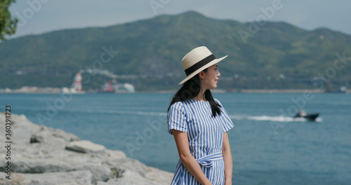 Woman look at the sea with straw hat © leungchopan