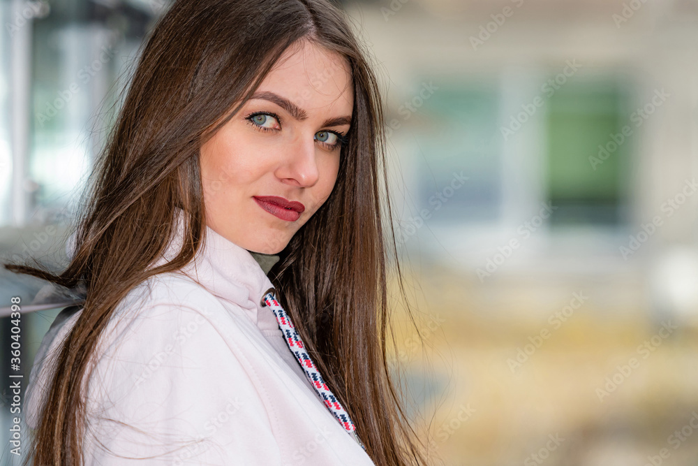 portrait of young emotional brunette woman on a defocused city background portrait of young emotional brunette woman on a defocused city background
