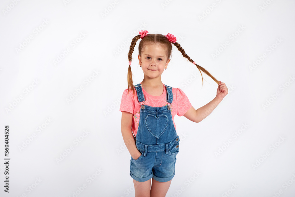 Cute small girl smailing and pulling her hair in the air, isolated on white background Cute small girl smailing and pulling her hair in the air, isolated on white background