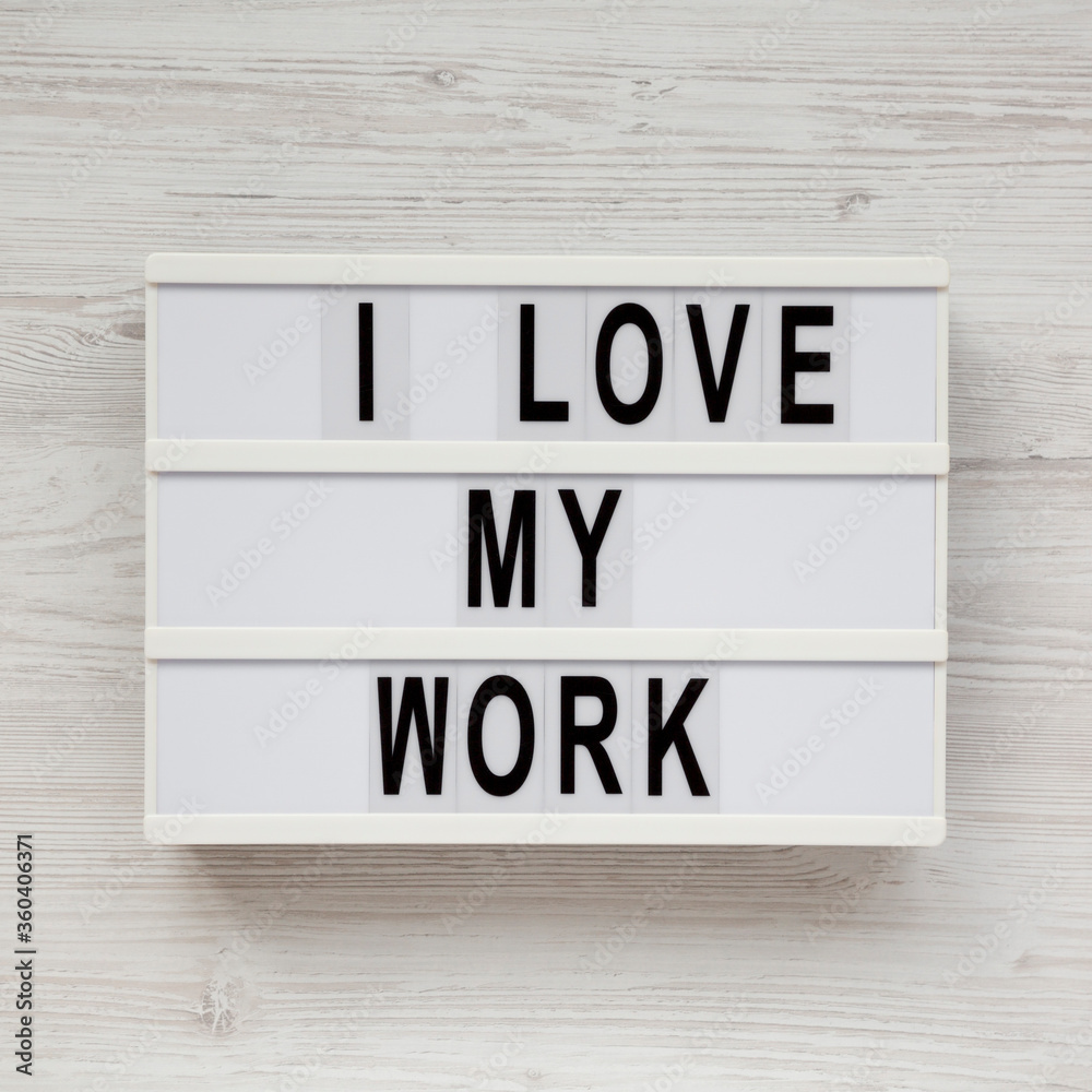 'I love my work' on a lightbox on a white wooden surface, top view. Flat lay, from above, overhead. 'I love my work' on a lightbox on a white wooden surface, top view. Flat lay, from above, overhead.