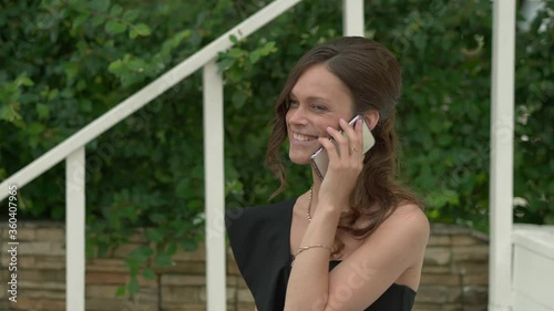 Pretty fashionable woman outdoors. Girl talks on the phone