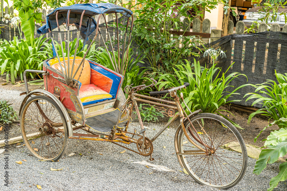 Tricycle taxi Of Thailand, parked in the garden area Which is an ancient tricycle