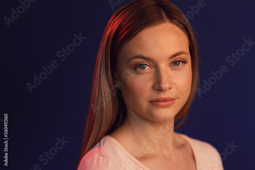 Caucasian woman with sad and serious face expression on dark blue