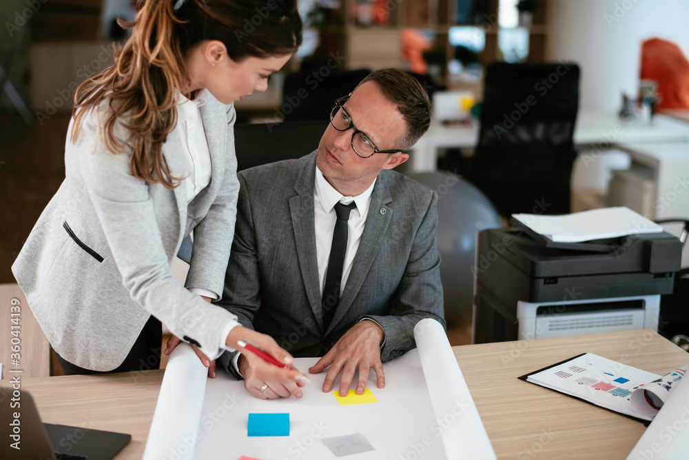 Colleagues in office. Businesswoman and businessman discussing work in office. Colleagues in office. Businesswoman and businessman discussing work in office.