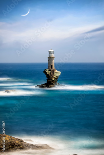 A lighthouse on a solid rock in the stormy sea as seen on Andros island, Cyclades, Greece