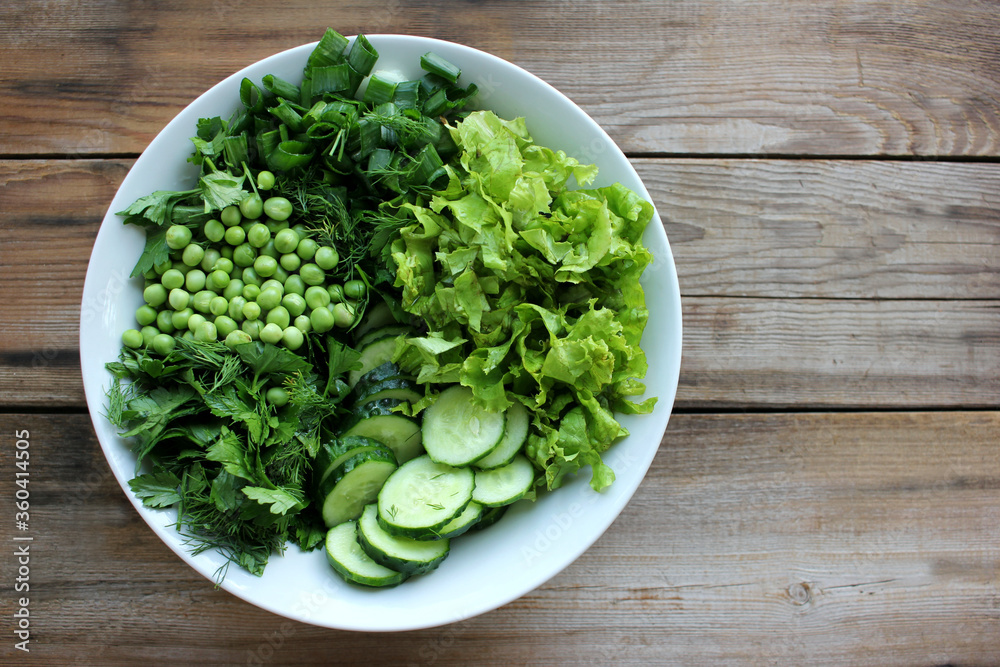 Healthy vegetarian salad bowl with green vegetables and herbs on wooden background. Fresh peas, cucumbers, green onions, dill, parsley, lettuce. Top view, copy space
Healthy vegetarian salad bowl with green vegetables and herbs on wooden background. Fresh peas, cucumbers, green onions, dill, parsley, lettuce. Top view, copy space