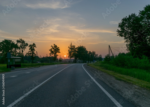 sunrise landscape, dark tree silhouettes, paved road texture, contrasting colors, summer