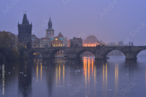 Charles Bridge in Prague Old Town on Vltava River. Bridge Tower. Early morning. Heavy fog.