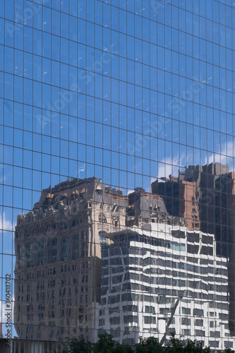 Buildings and sky reflected in the glass windows of a skyscraper in New York  USA. Vertical image  copy space