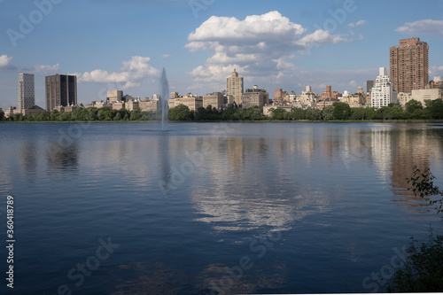 Buildings and clouds reflection in Central Park late in the afternoon in midtown Manhattan in New York City. Copy space