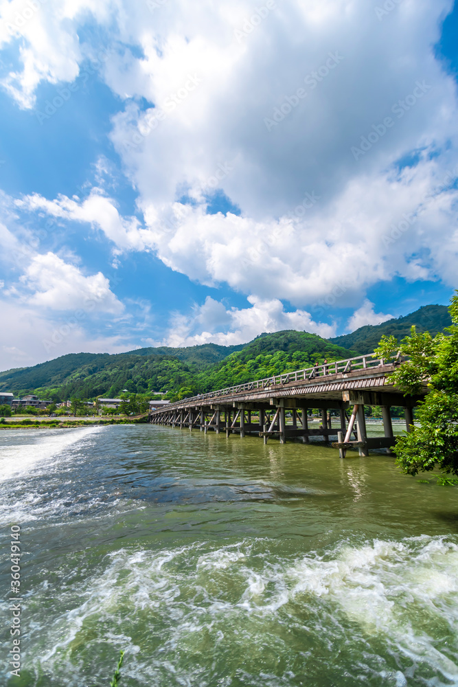 Togetsukyo Bridge in Arashiyama, Kyoto, Japan. vivid fresh greenery in early summer and the Katsuragawa river flowing vigorously.