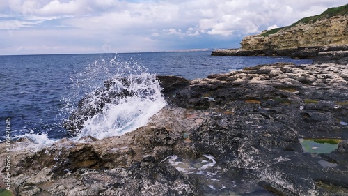 Water breaking through a hole in a stone