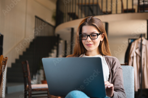 Young businesswoman sitting in cafe with laptop and planning new trip