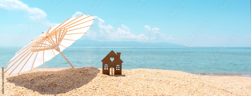 Small house and umbrella on sand, beach, blue sea and sky on blurred ...