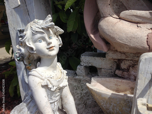 Girl child garden statue smiling on a sunny day