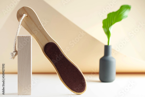 File for heels with a wooden handle on a light background. The concept of pedicure, body care spa. Copy space.