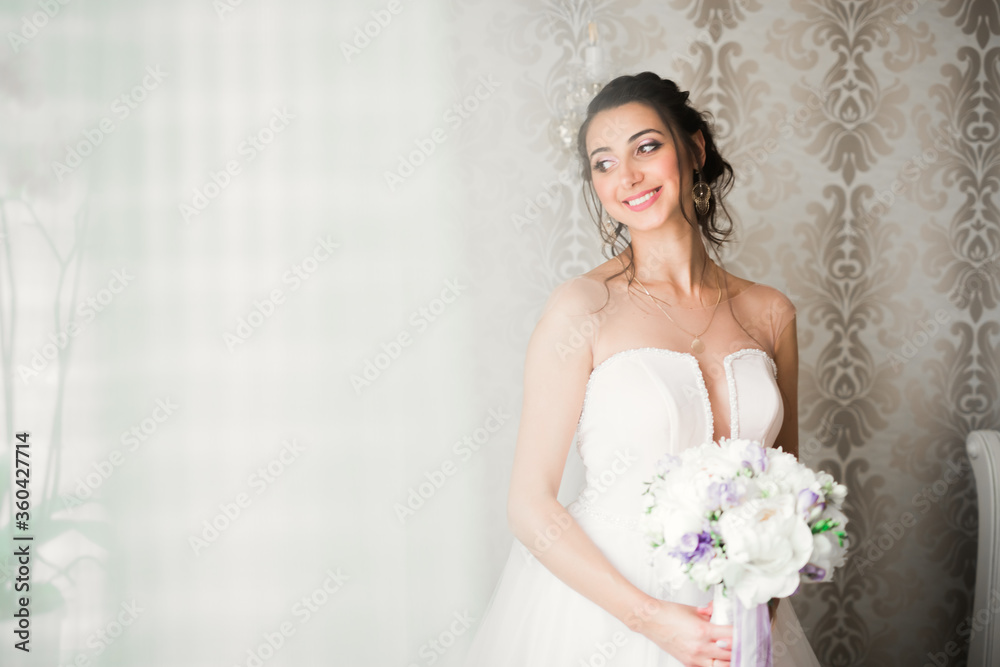 Gorgeous bride in robe posing and preparing for the wedding ceremony face in a room Gorgeous bride in robe posing and preparing for the wedding ceremony face in a room