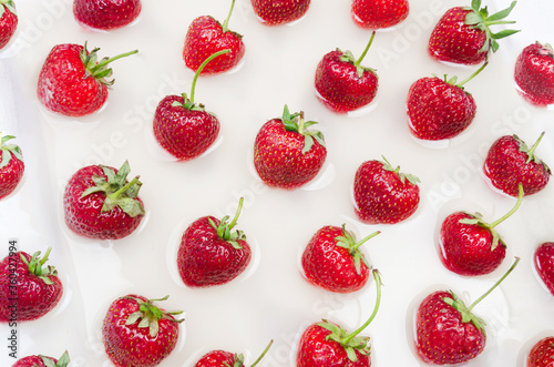 Fototapeta Naklejka Na Ścianę i Meble -  Fresh red trawberries on liquid background. Flat lay pattern