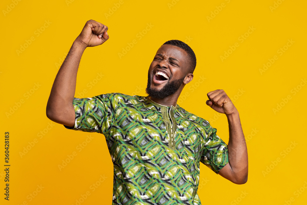 Black man showing positive emotions over yellow background Black man showing positive emotions over yellow background