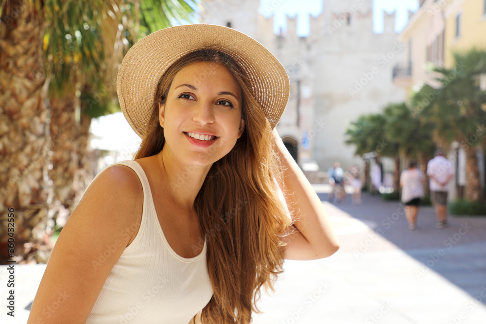 Portrait of young traveler woman visiting Europe. Beautiful tourist girl enjoying her holidays in Sirmione, Italy.