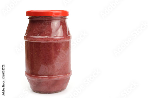 Glass jar with strawberry or raspberry jam isolated on the white background