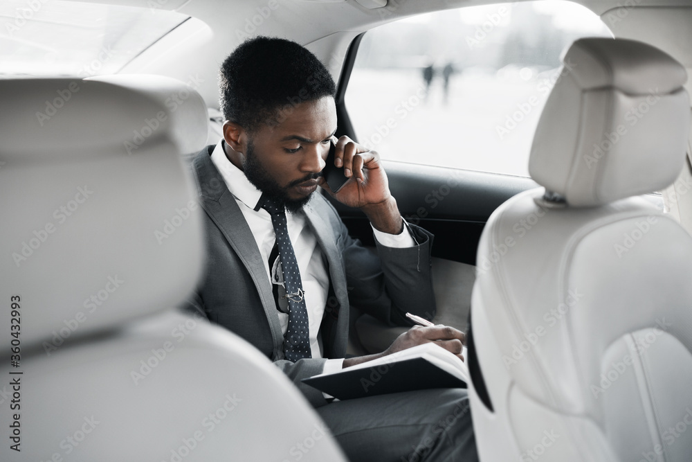 Busy Businessman Talking On Phone Taking Notes Sitting In Car