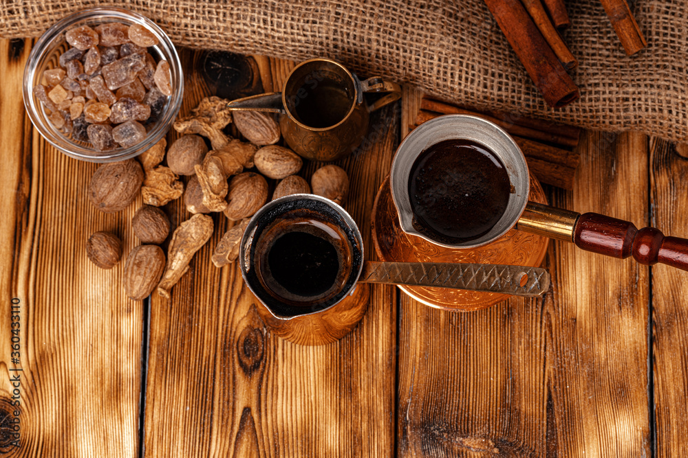 Shiny copper turk with brewed coffee on brown wooden table Shiny copper turk with brewed coffee on brown wooden table