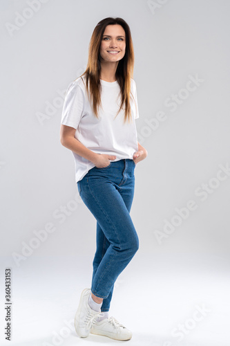 Full portrait of a beautiful young happy woman standing over white background.