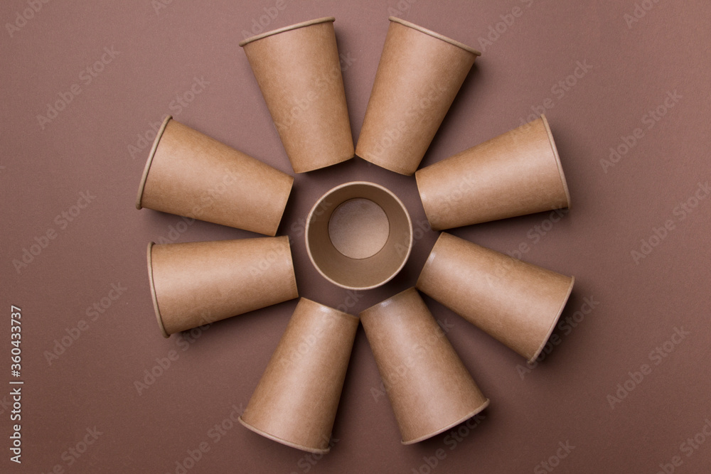 flower made of brown eco-friendly cardboard cups on brown colored paper background. top view. close-up. mock-up flower made of brown eco-friendly cardboard cups on brown colored paper background. top view. close-up. mock-up