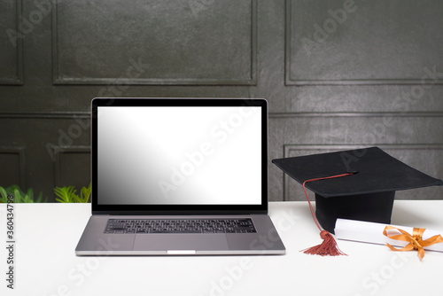 Graduation hat and certificate with laptop mockup