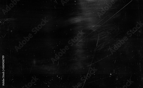 Dust scratches background. Grain texture. Black distressed surface with white smeared stains. photo