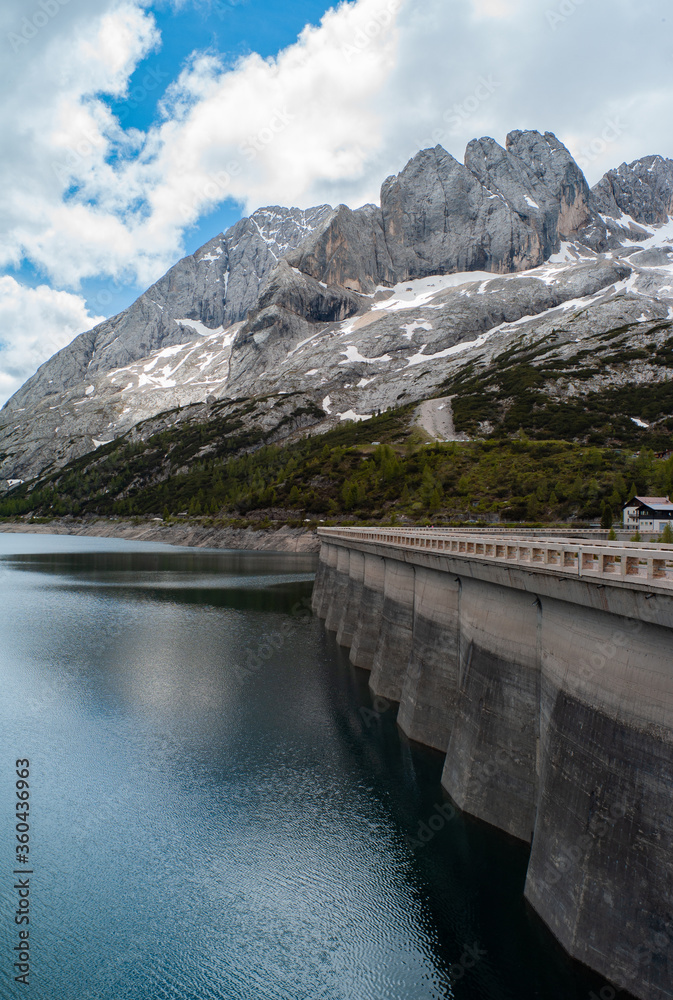 a small lake in south tyrol with mirrored mountains in the water and cloudy sky a small lake in south tyrol with mirrored mountains in the water and cloudy sky