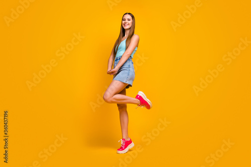 Full length body size view of her she nice attractive lovely winsome lovable cheerful cheery straight-haired girl posing having fun isolated over bright vivid shine vibrant yellow color background